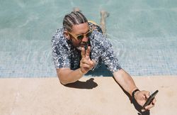 Older man using smartphone in swimming pool