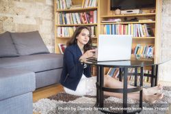 Smiling woman using a laptop at home 5nnzQ5