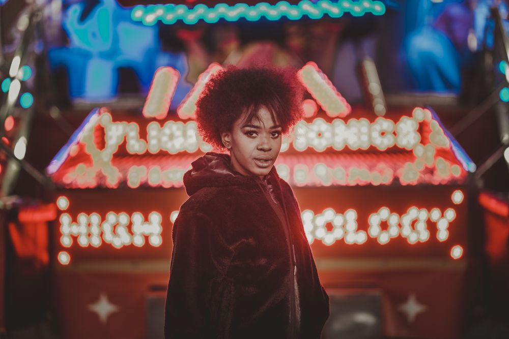 Black female standing near attraction in amusement park