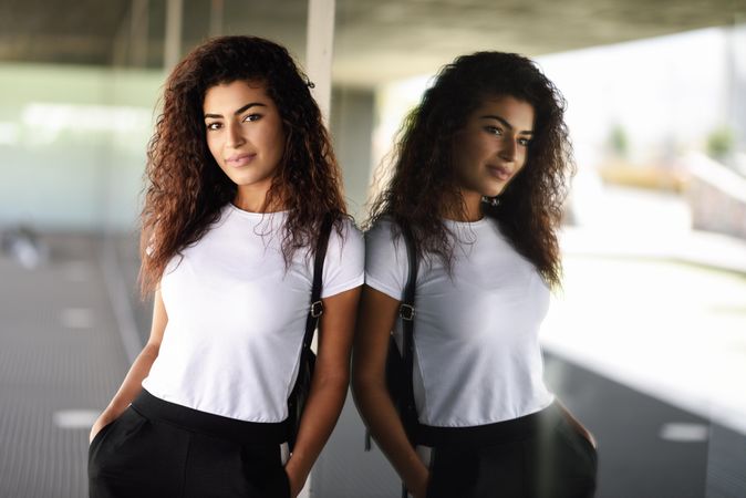 Arab woman leaning against window of corporate office building