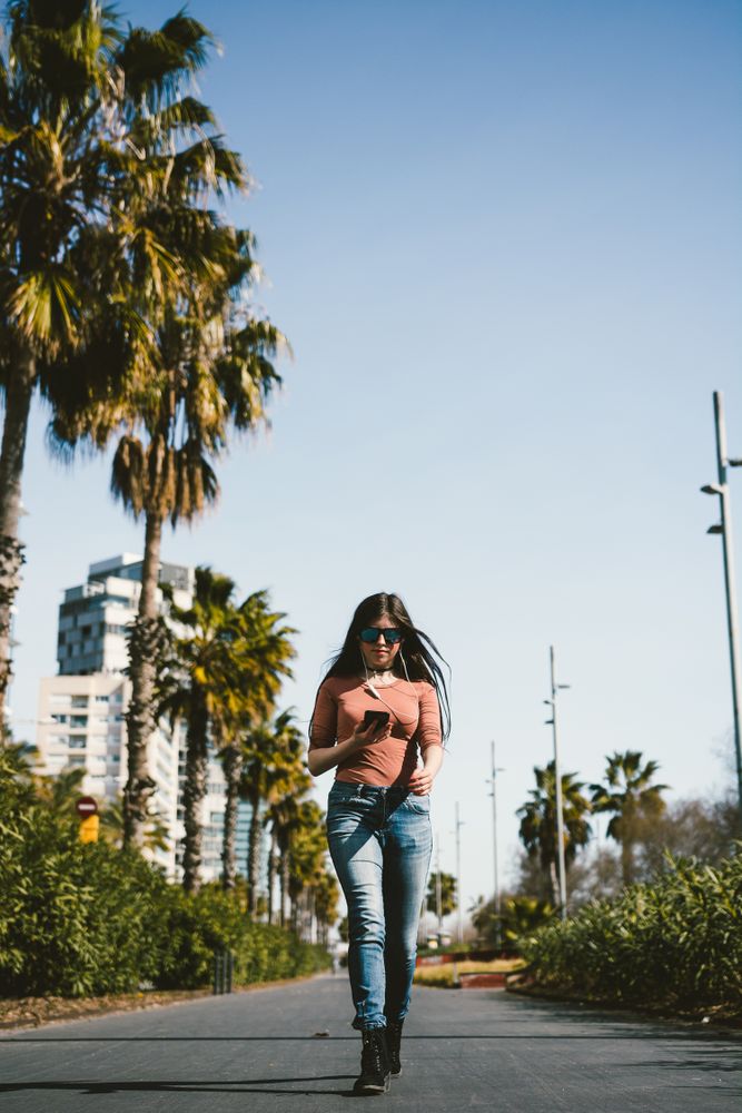 Teen girl walking happily through the streets.
