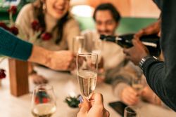 Point of view shot of being served a glass of champagne during a festive celebration.