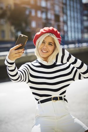 female in red beret taking selfie
