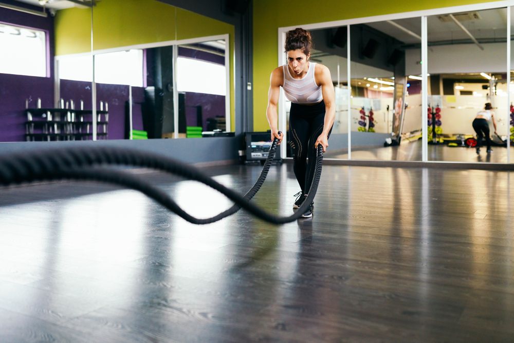 Woman working out upper body with ropes