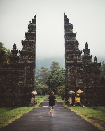 Man running into gates of ancient temple