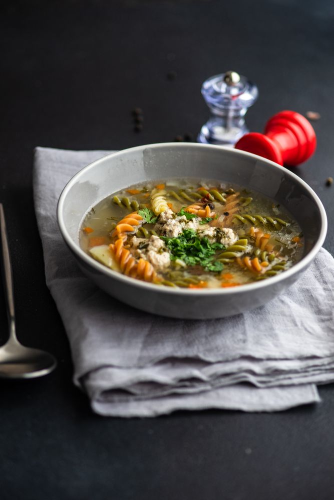 Pasta and meat ball soup served on the table with copy space