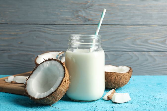 Coconut and milk on blue background, close up