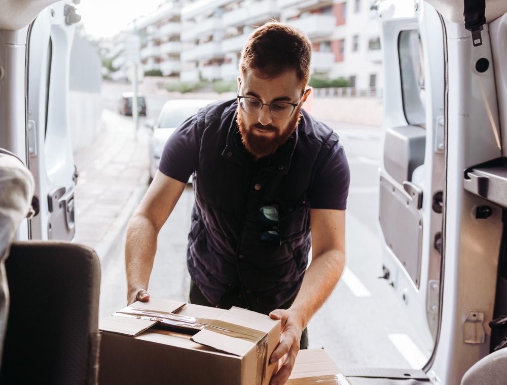 Courier taking out cartons of car for delivery completion