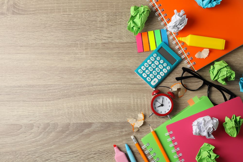 Top view of stationary and notebooks on wooden table with space for text