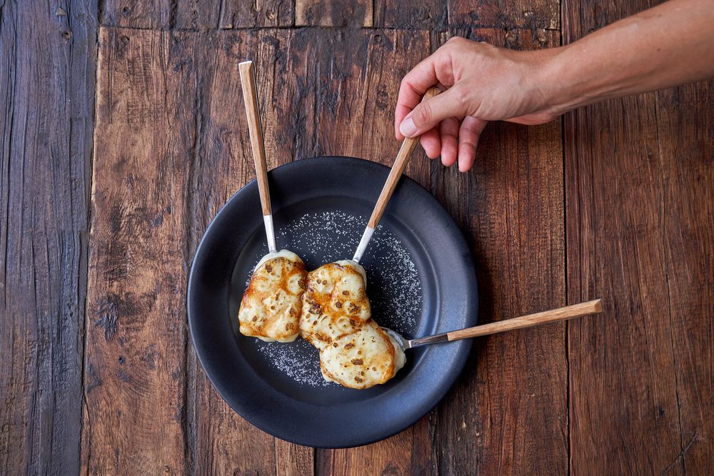 Crop person with delicious pastry on wooden table