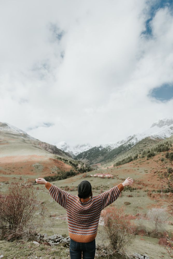 Young woman standing in a beautiful landscape between mountains