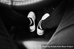 Grayscale photo of person's feet in light shoes bY77G5