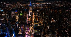 Aerial View of Manhattan Architecture at Night. Evening Photo of Financial Business District from a Helicopter. Scenery of Historic Office Towers, Illuminated Skyscrapers