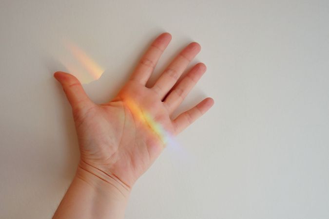 Colorful light reflection on person's hand