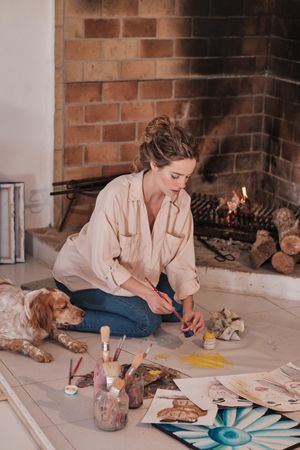Young woman drawing with dog