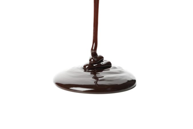 Melted chocolate is pouring, isolated on blank background