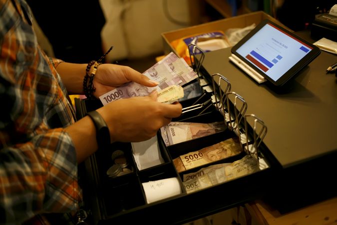 Cashier at til handling money after payment