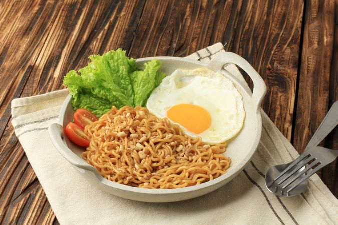 Indomie goreng, Indonesian noodles and egg on wooden table