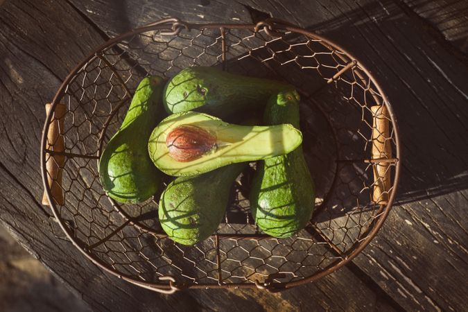 Green avocado in metal basket