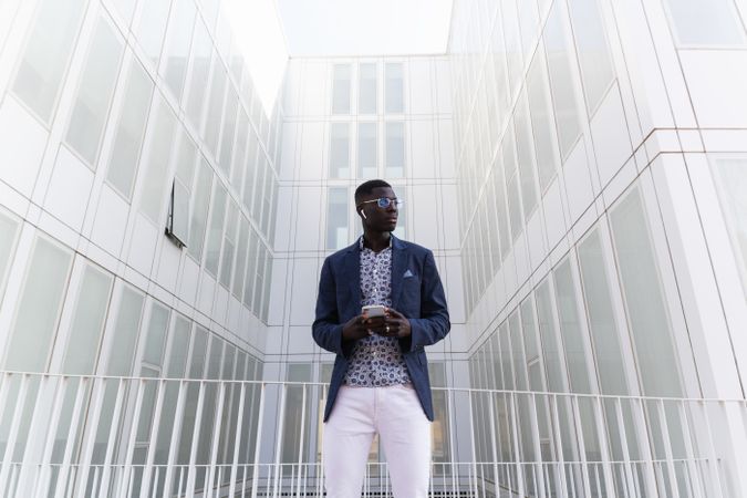 Black businessman listening to music in earbuds in city