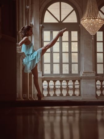 Graceful woman in pointe raising leg in cathedral