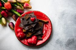 Dark chocolate with heart decorations and tulips