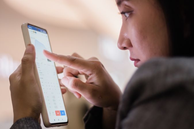 Woman analyzing data on smartphone screen