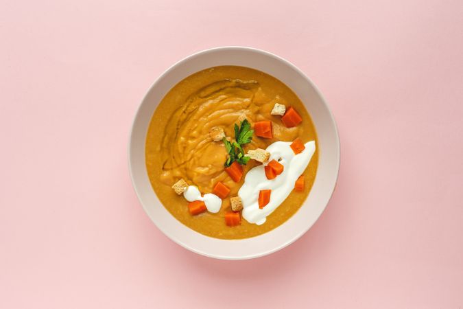Orange vegetable cream with slices of carrots and herbs