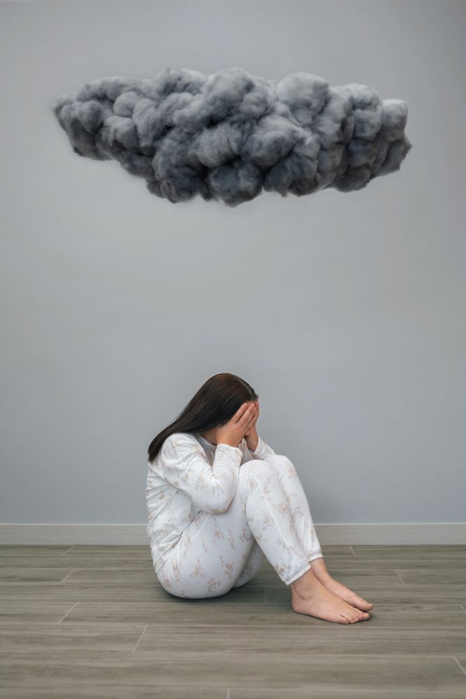 Unrecognizable woman under a dark storm cloud