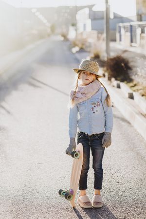 Stylish girl with skateboard on street