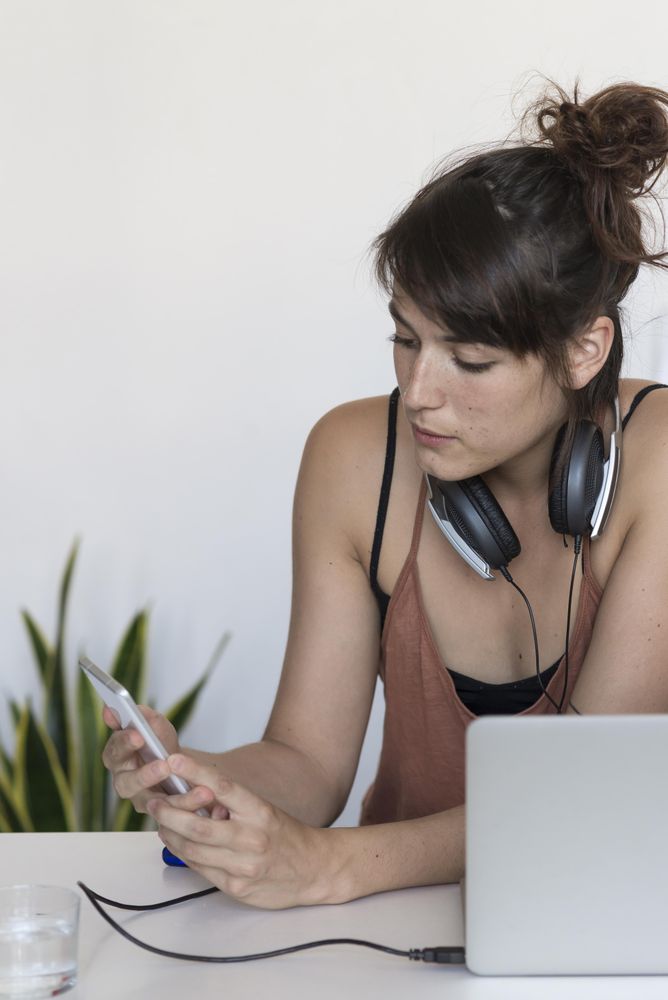 Female looking at phone screen in home office