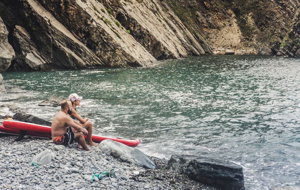 Couple with paddleboards looking at wonderful sea
