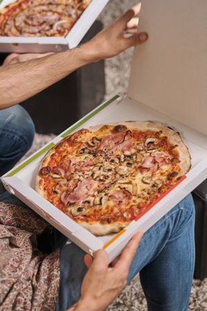 Anonymous males eating pizza in living room