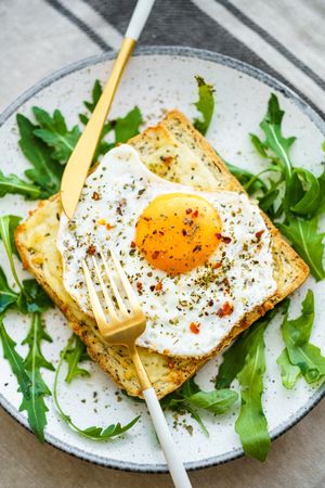 Delicious breakfast of fried eggs with toast and salad.