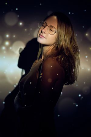 Young female with closed eyes under sparks