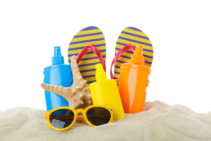 Summer vacation accessories in clear sea sand isolated on plain background. Summer vacation