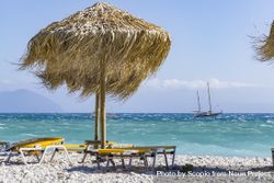 Beach chair and straw umbrella on seashore bG6gY4