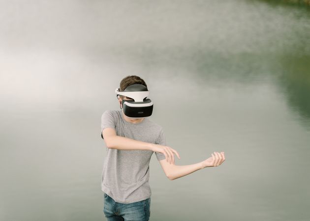 Young teenager with virtual reality glasses outdoors