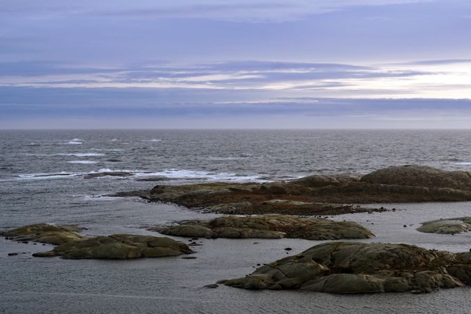 Rocky seashore and dark wavy sea in dusk