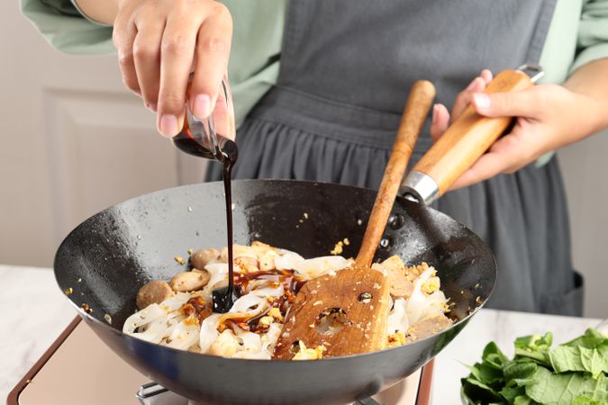 Pour Sweet Soy Sauce Kecap to the Pan with Kwetiau, Chinese Rice Noodles.