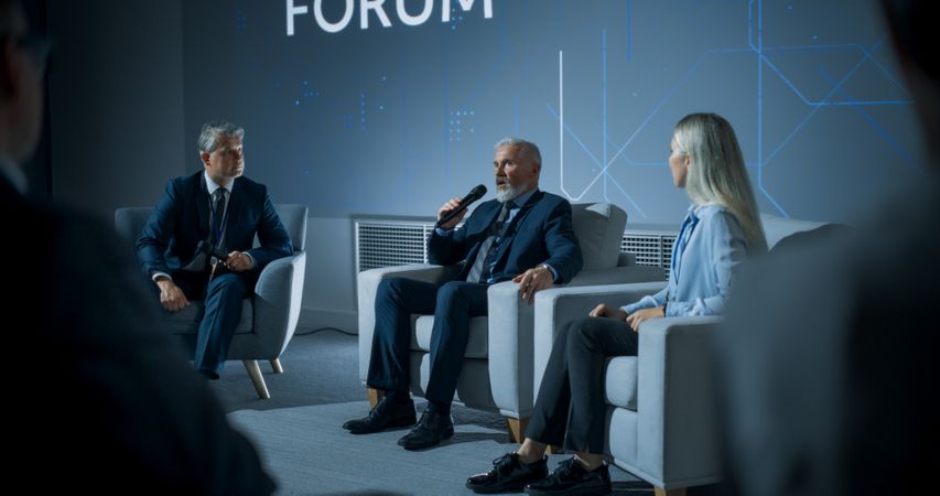 International Technology Conference: Host Asking Male CEO a Question In Front Of Audience.