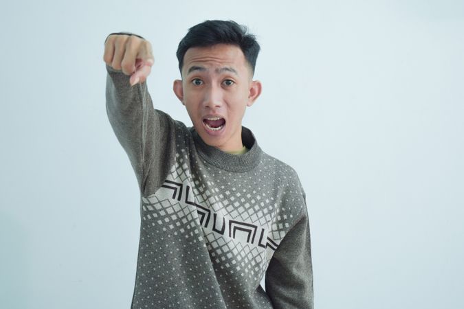 Asian young man  pointing at camera