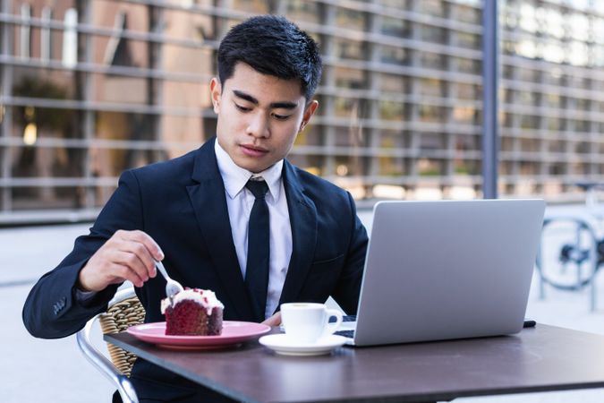 Businessman eating dessert in street cafe