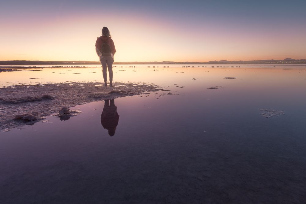Woman admiring beautiful sky on empty beach