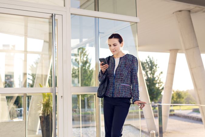 Businesswoman using smartphone outside building