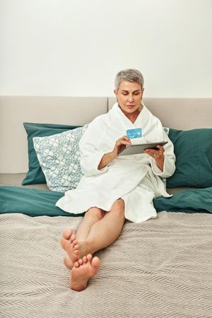 Mature woman relaxing at home with credit card