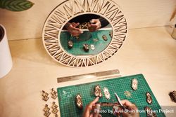 Black jewelry designer working on earrings with mirror 0VK2O5