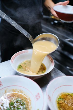 Crop person pouring bouillon in bowl