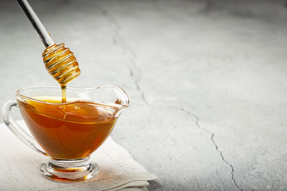 Honey in glass bowl on the table.