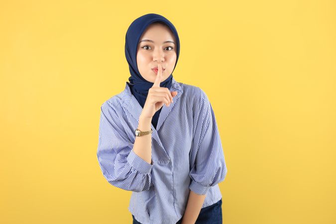 Serious Young Asian Muslim Woman Showing Silence Gesture